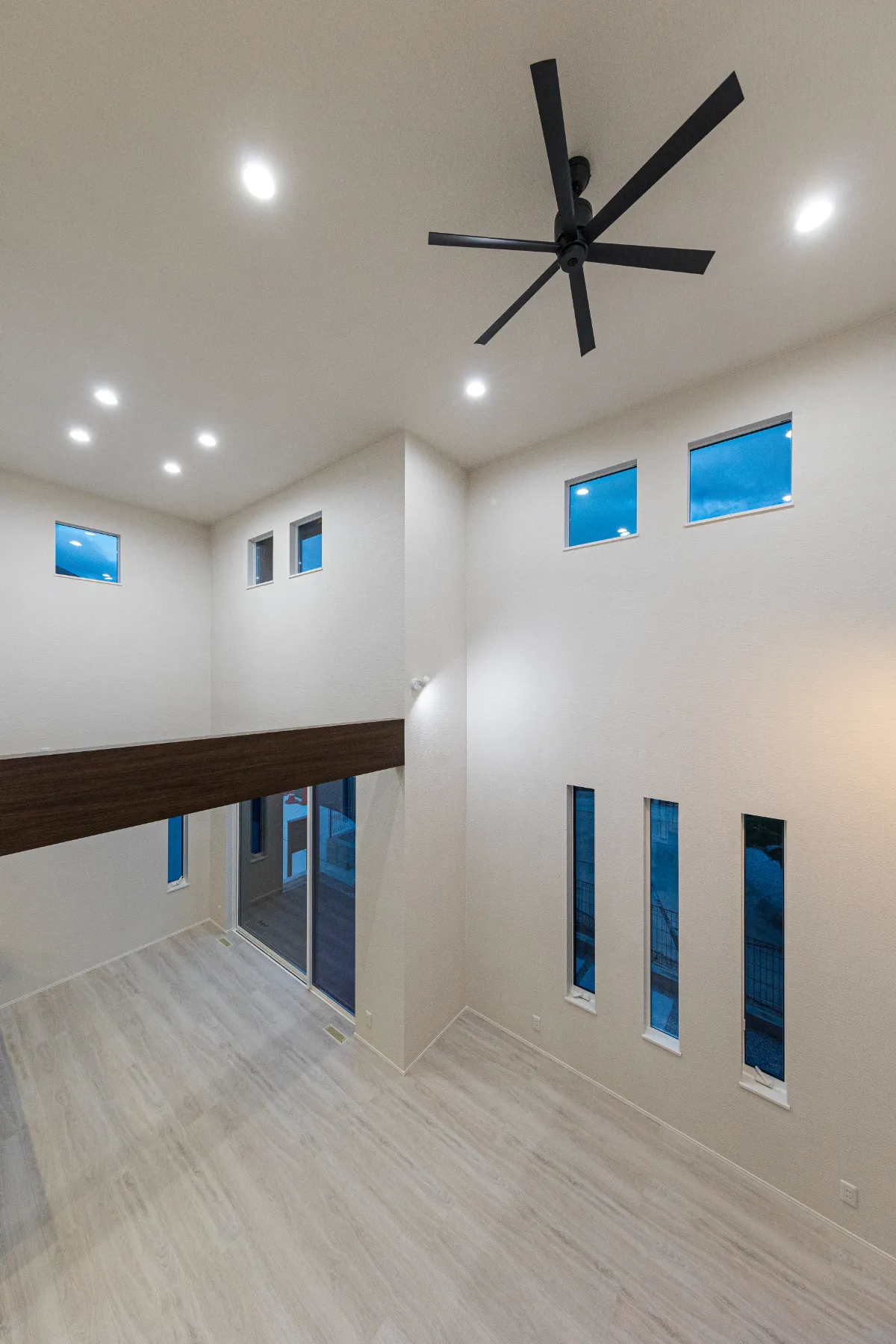 高窓と縦長窓から外光が入る、吹き抜けの開放感あふれるリビング上部の様子