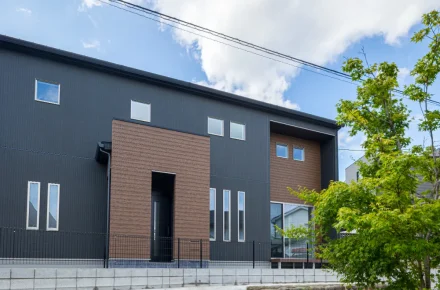 植栽が映える、シックな色合いのモダン住宅の外観全景