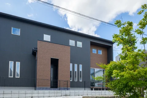 植栽が映える、シックな色合いのモダン住宅の外観全景