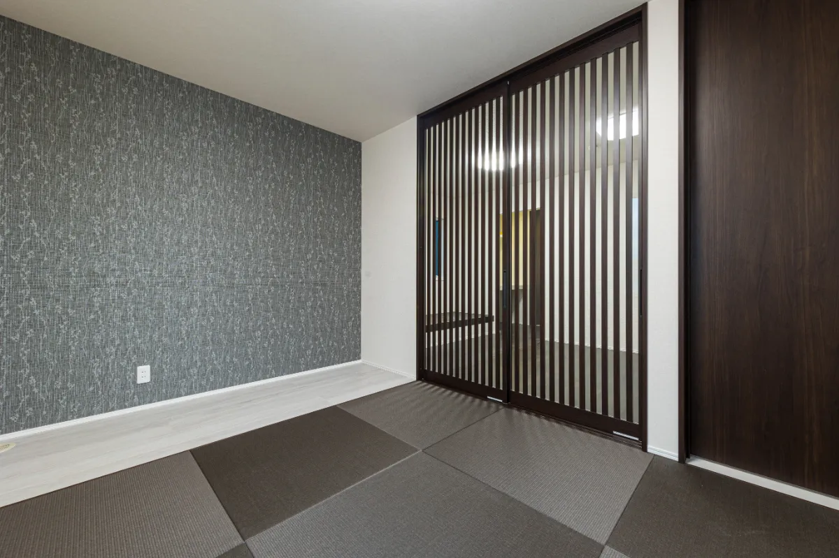 壁一面に落ち着いた柄のアクセントクロスを配した和室