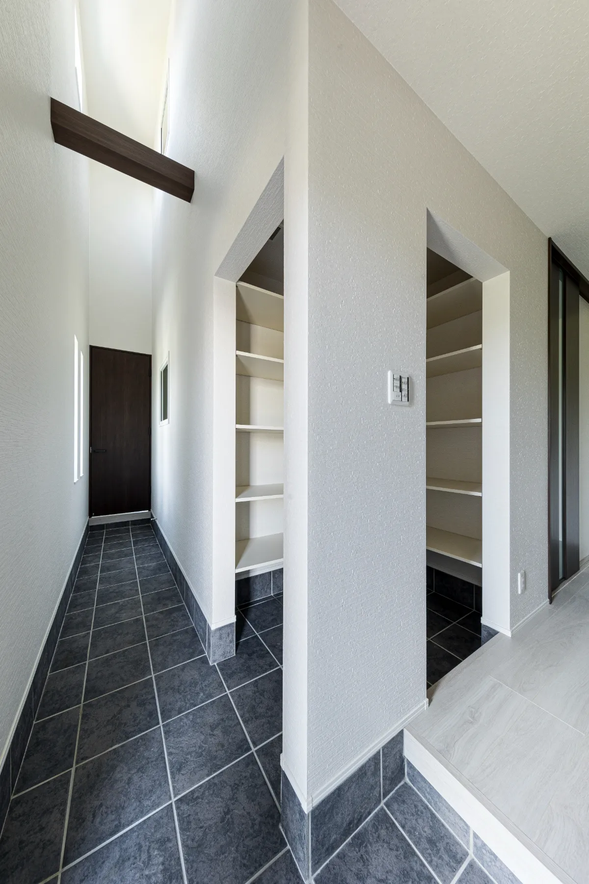 高天井とスリット窓から光が差し込む玄関スペース