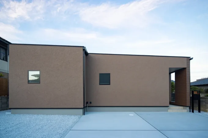 正面から見た塗り壁仕上げのシンプルな平屋の外観