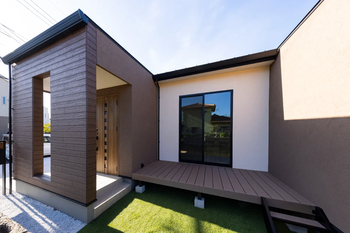 玄関とウッドデッキが隣接したコの字型の住まい