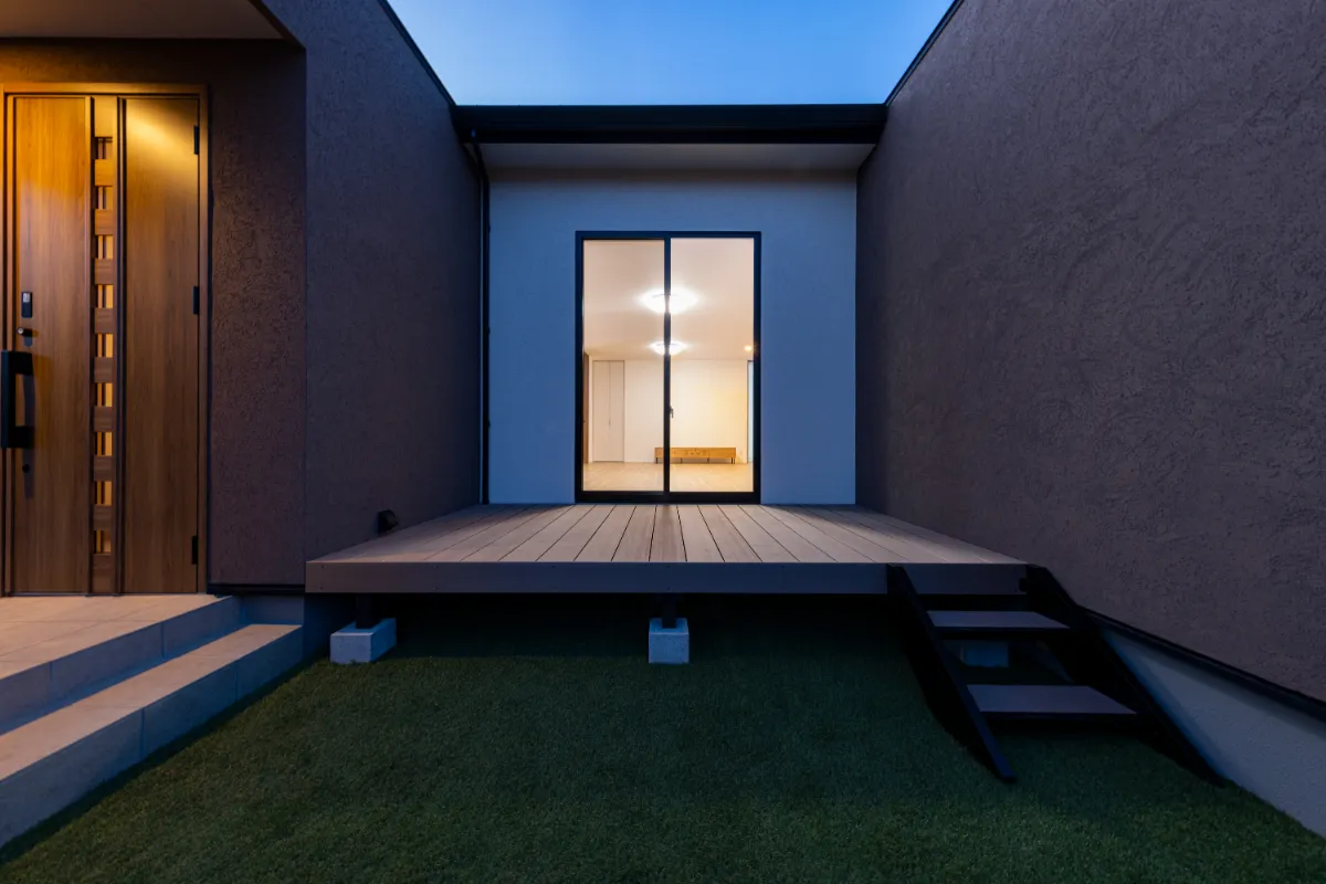 夜間の中庭側から見たウッドデッキと掃き出し窓