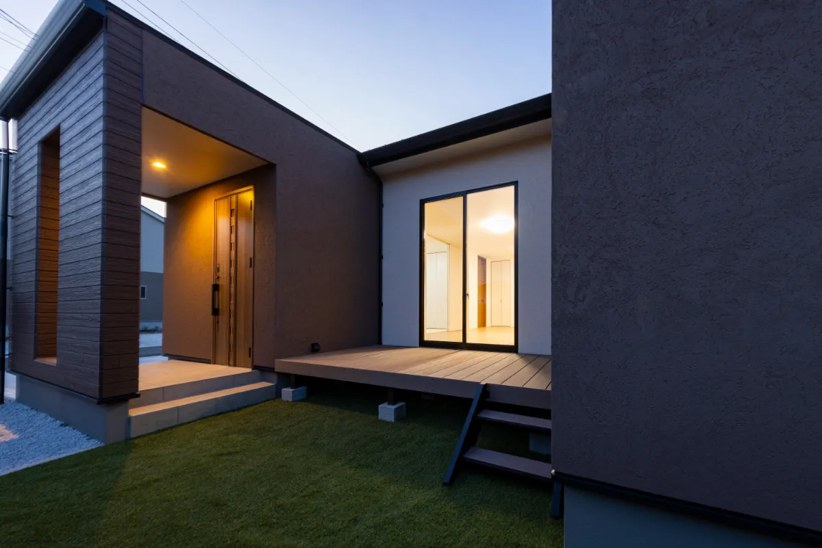 夕暮れ時、玄関と中庭を包むように照らす外灯のあかりが印象的な一枚