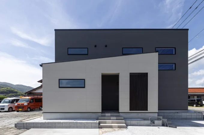 ホワイトとダークグレーのツートンカラーがシャープな印象を与えるモダンな住宅外観