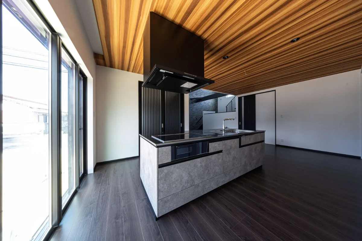 ダイナミックな木目天井と石調のアイランドキッチン