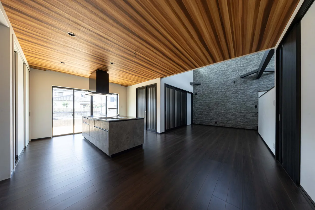 木目の天井と石目調キッチンが調和する開放的なLDK空間