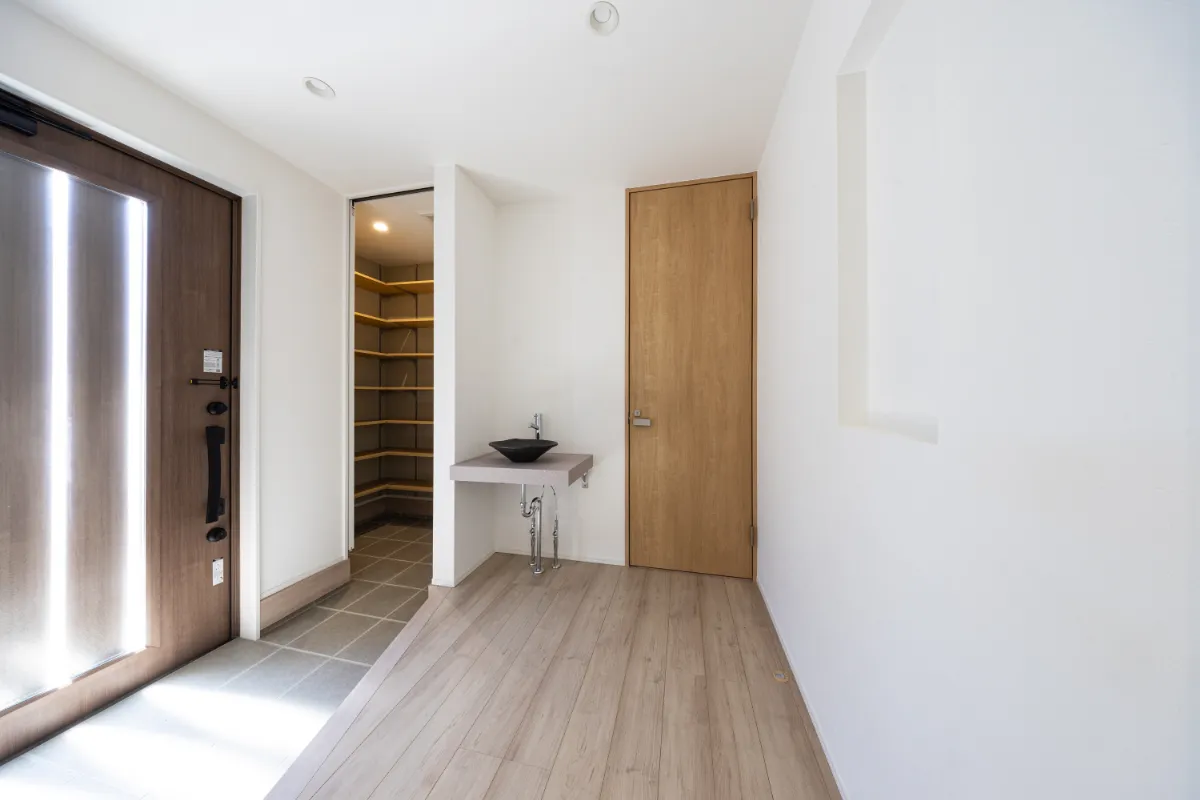 玄関ホールに設けられた手洗いカウンターと、奥に広がる収納力抜群のシューズクローク