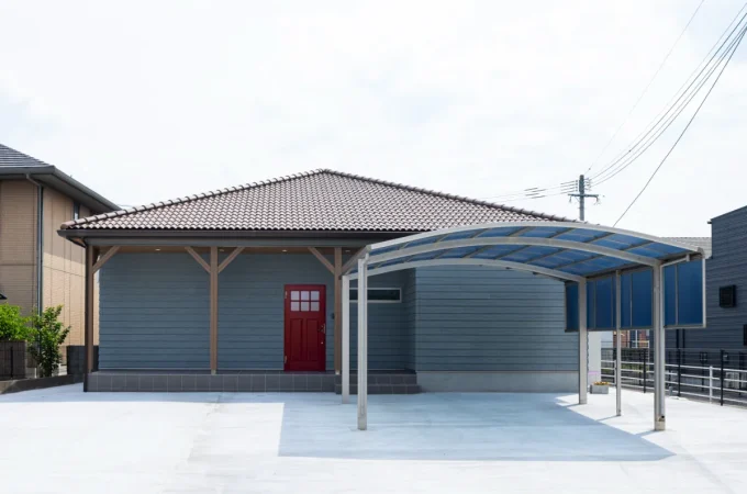 インディゴブルーの外壁と赤い玄関ドアが印象的なアメリカンスタイルの平屋正面外観