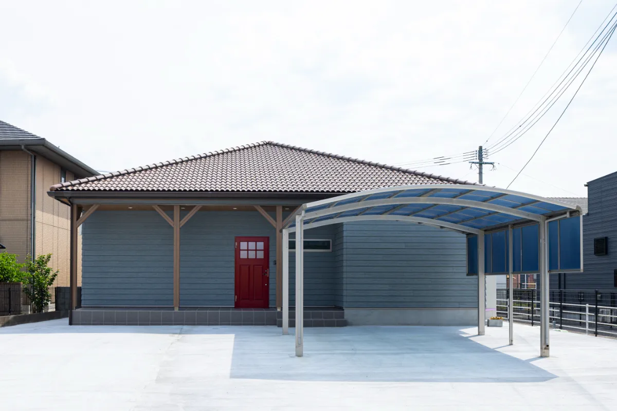 インディゴブルーの外壁と赤い玄関ドアが印象的なアメリカンスタイルの平屋正面外観