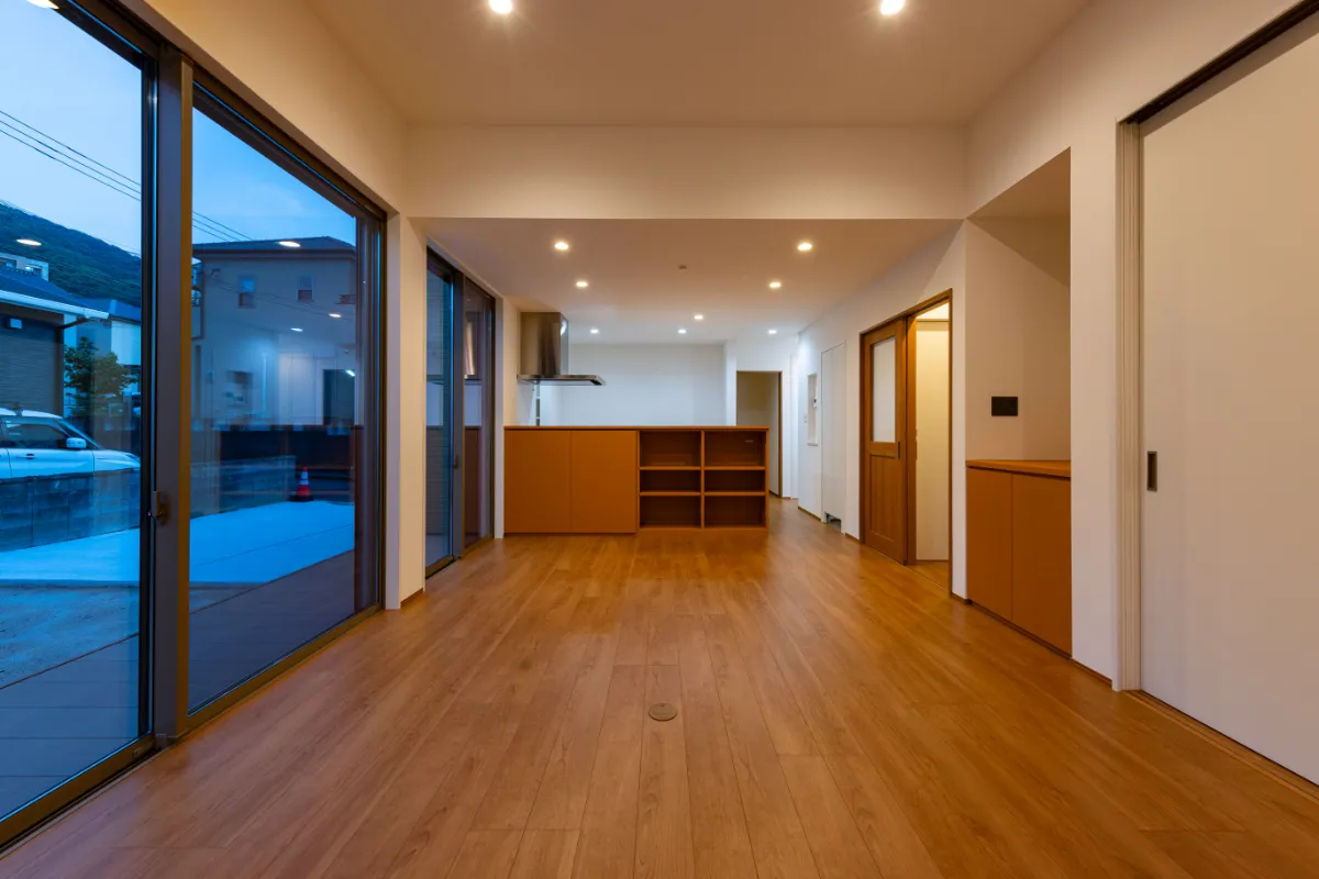 夜の灯りが心地よく映える、大開口の窓に囲まれたリビング空間