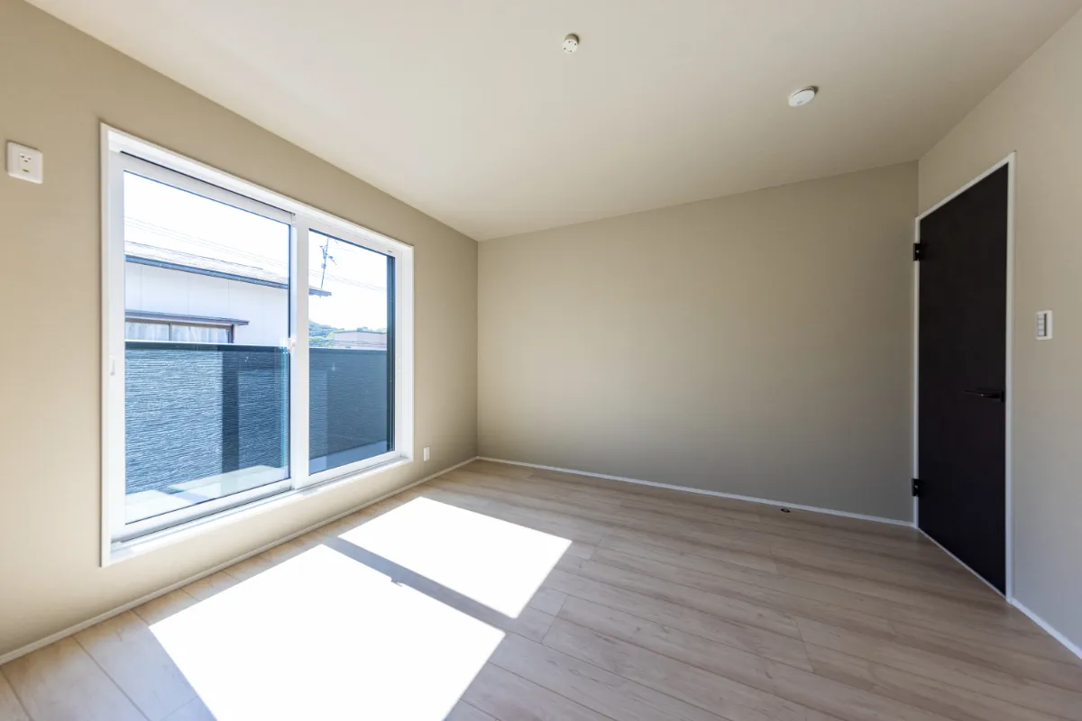 ベージュの壁と明るいフローリングが調和した洋室