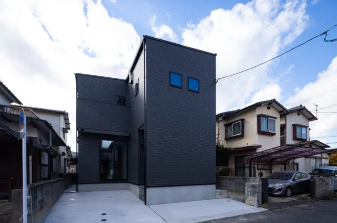 斜め前方から撮影されたシャープなフォルムと黒の外壁が際立つ外観