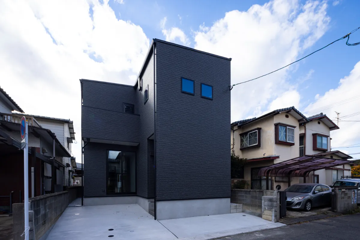 斜め前方から撮影されたシャープなフォルムと黒の外壁が際立つ外観