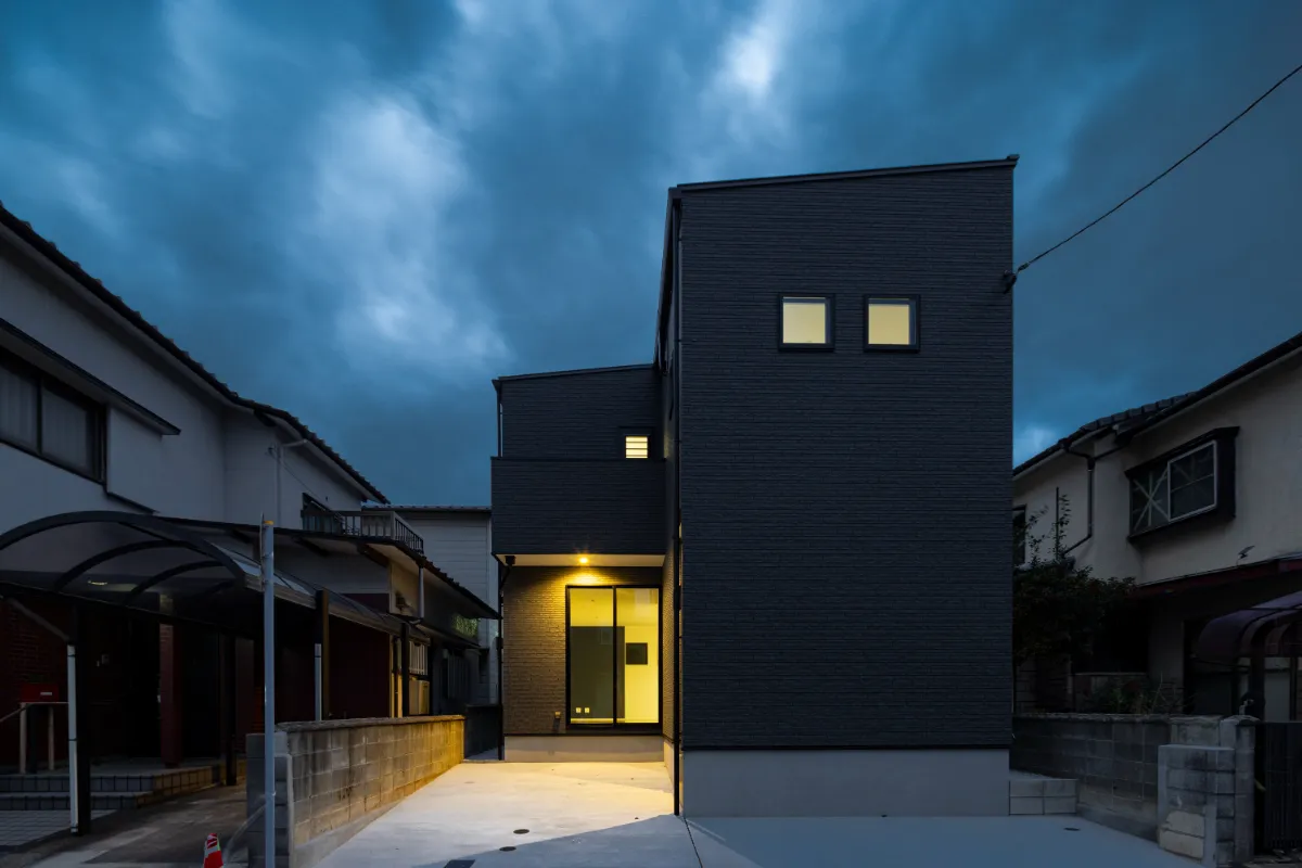夕暮れ時に照明が灯った住宅の正面