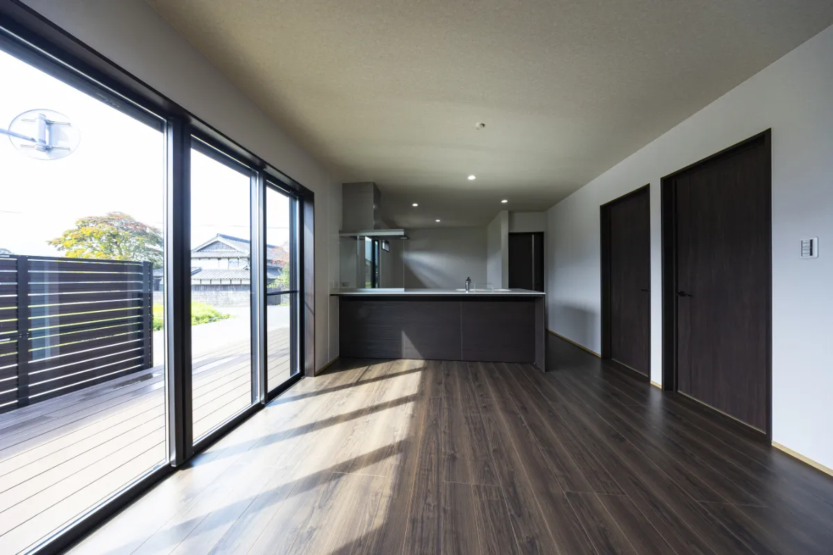 ダークウッド調のフローリングとキッチンが印象的なリビング