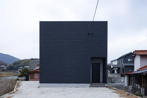 正面に窓のない、黒のキューブ型住宅の外観