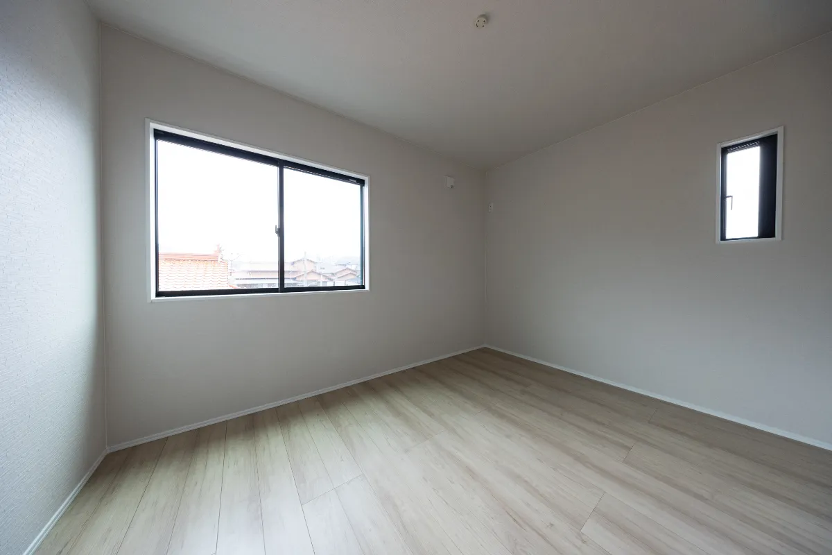 ナチュラルな木目フローリングとホワイトの壁が広がる洋室