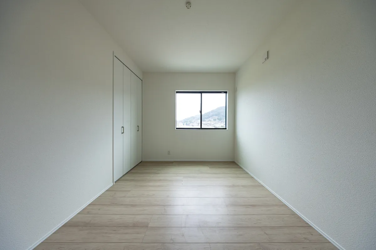 窓からの眺望とナチュラルカラーの内装が、落ち着いた印象を与えるクローゼット付きの洋室