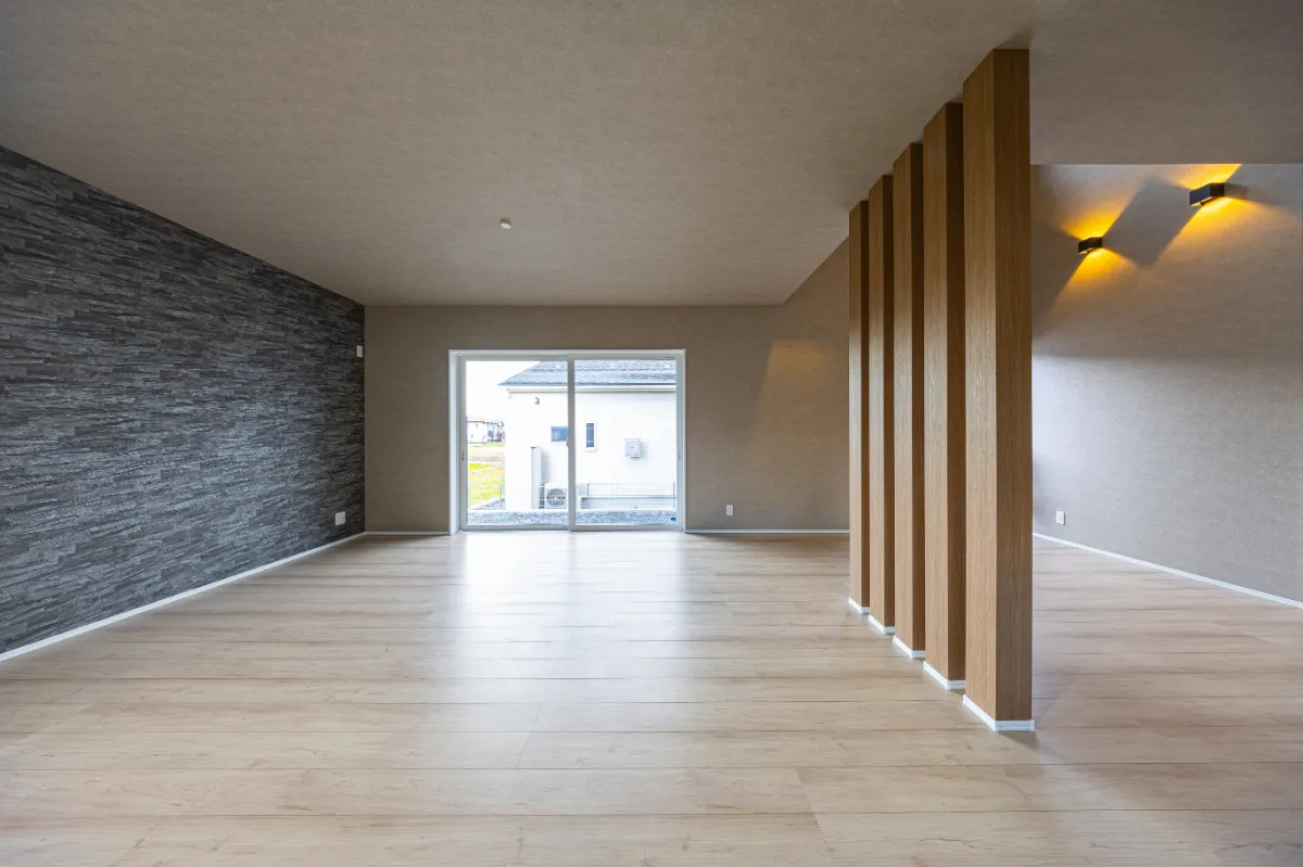 大きな掃き出し窓から光が差し込む明るいリビング。外とのつながりを感じられる開放的な空間です。