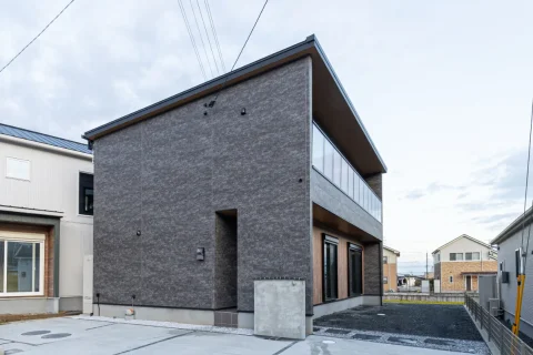 大きなバルコニーと片流れ屋根が特徴的な外観。建物の立体感と開放感が伝わる角度からの全景です。