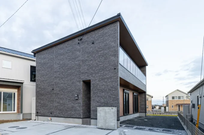 大きなバルコニーと片流れ屋根が特徴的な外観。建物の立体感と開放感が伝わる角度からの全景です。