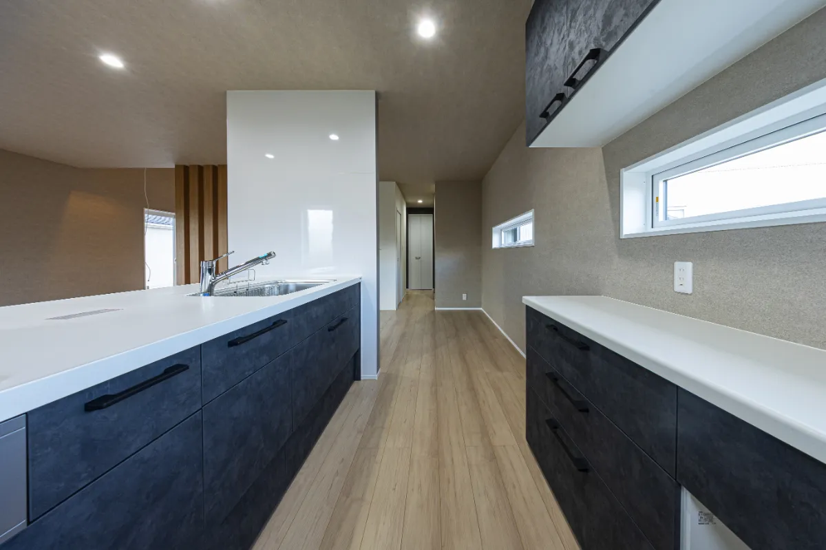 広々としたカウンターと背面収納を備えたキッチンスペース。動線にゆとりがあり、複数人でも快適に使える設計です。