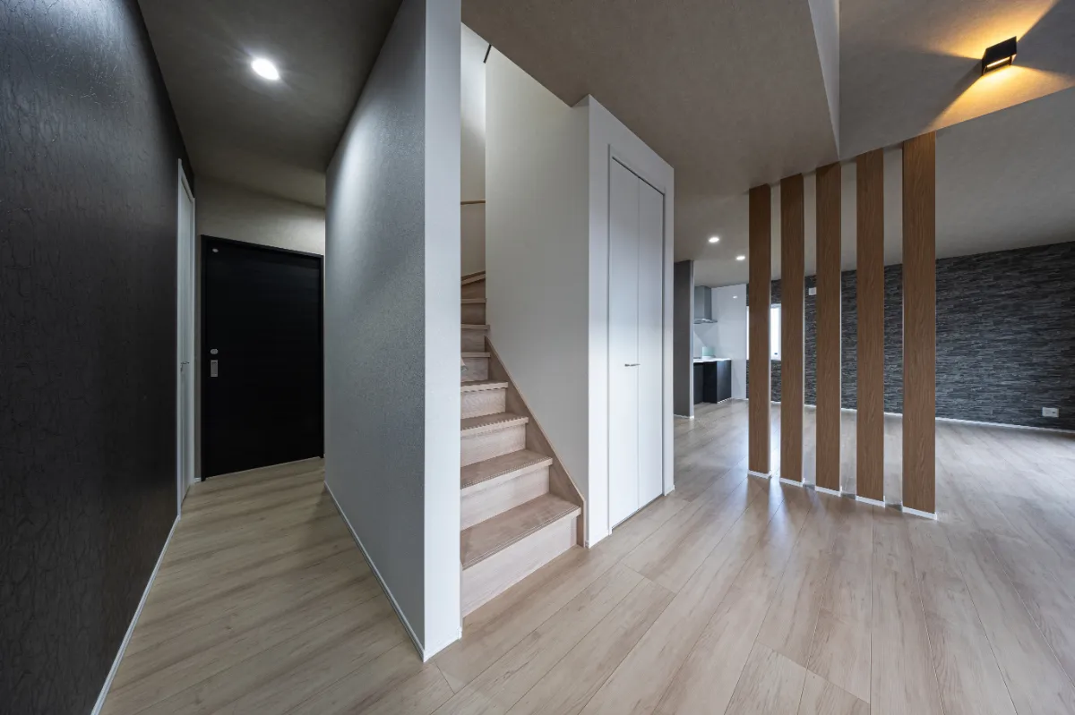 玄関ホールから階段、LDKへと続く動線。白とグレーを基調にした落ち着いた空間に、木のアクセントがやさしく映えます。