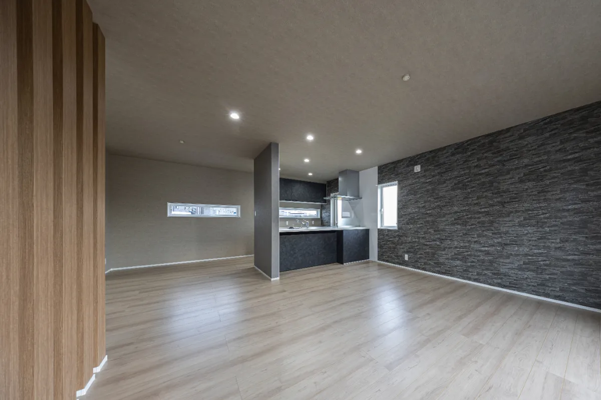 キッチンとリビングがひと続きになった広々としたLDK。床材と壁の色味を揃え、統一感のある空間に仕上げています。