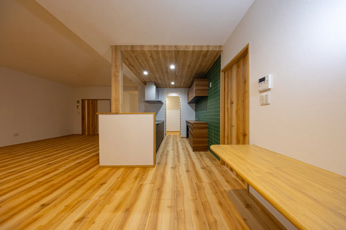 木目の床と天井に包まれたキッチンスペース。リビングとゆるやかにつながり、家族の気配を感じながら料理ができる配置です。