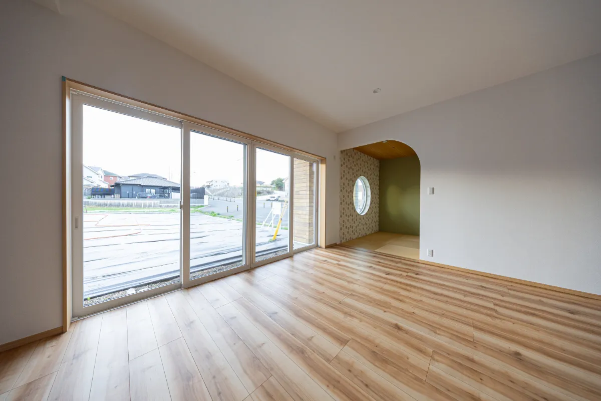 キッチン側から見たリビングと和室スペース。アーチ開口が空間のアクセントになっています。