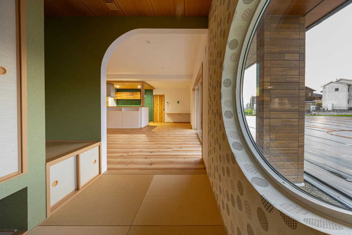 丸窓からやわらかな光が入る和室。畳と木天井がつくる落ち着いた空間から、LDKまで視線が抜ける開放的なつながりが魅力です。