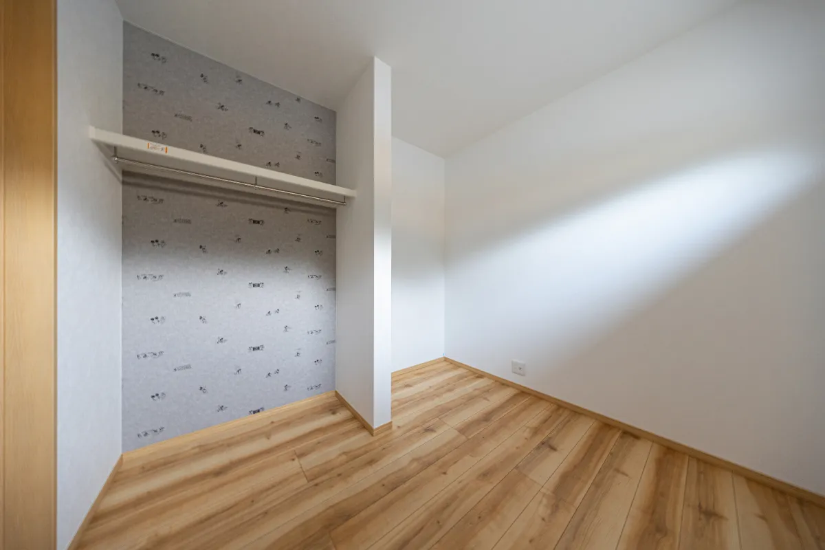 クローゼット背面にアクセントクロスを採用した洋室。さりげない柄が空間に表情を加えています。