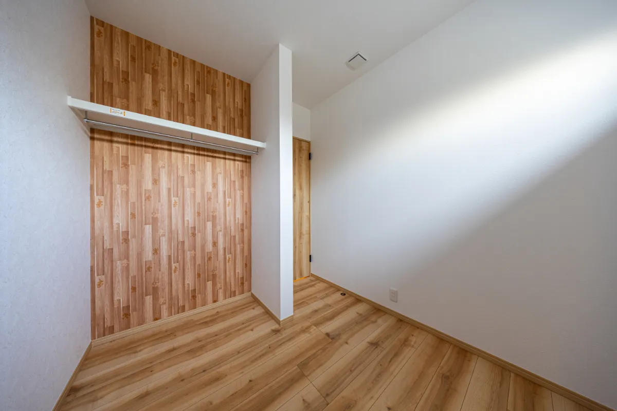 木目調クロスが印象的な収納付き洋室。落ち着いた色合いで、寝室や子ども部屋など幅広く使えます。