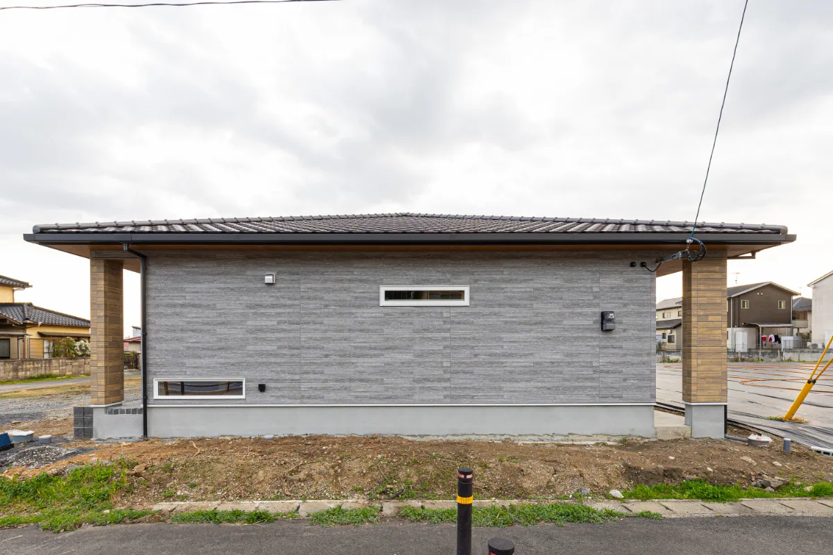 横に広がるフォルムが特徴的な外観側面。スリット窓でプライバシーに配慮しながら、採光もしっかり確保しています。