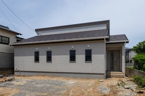 水平ラインが美しい平屋の外観。明るい外壁と落ち着いた屋根色の組み合わせで、すっきりとした佇まいに仕上げています。