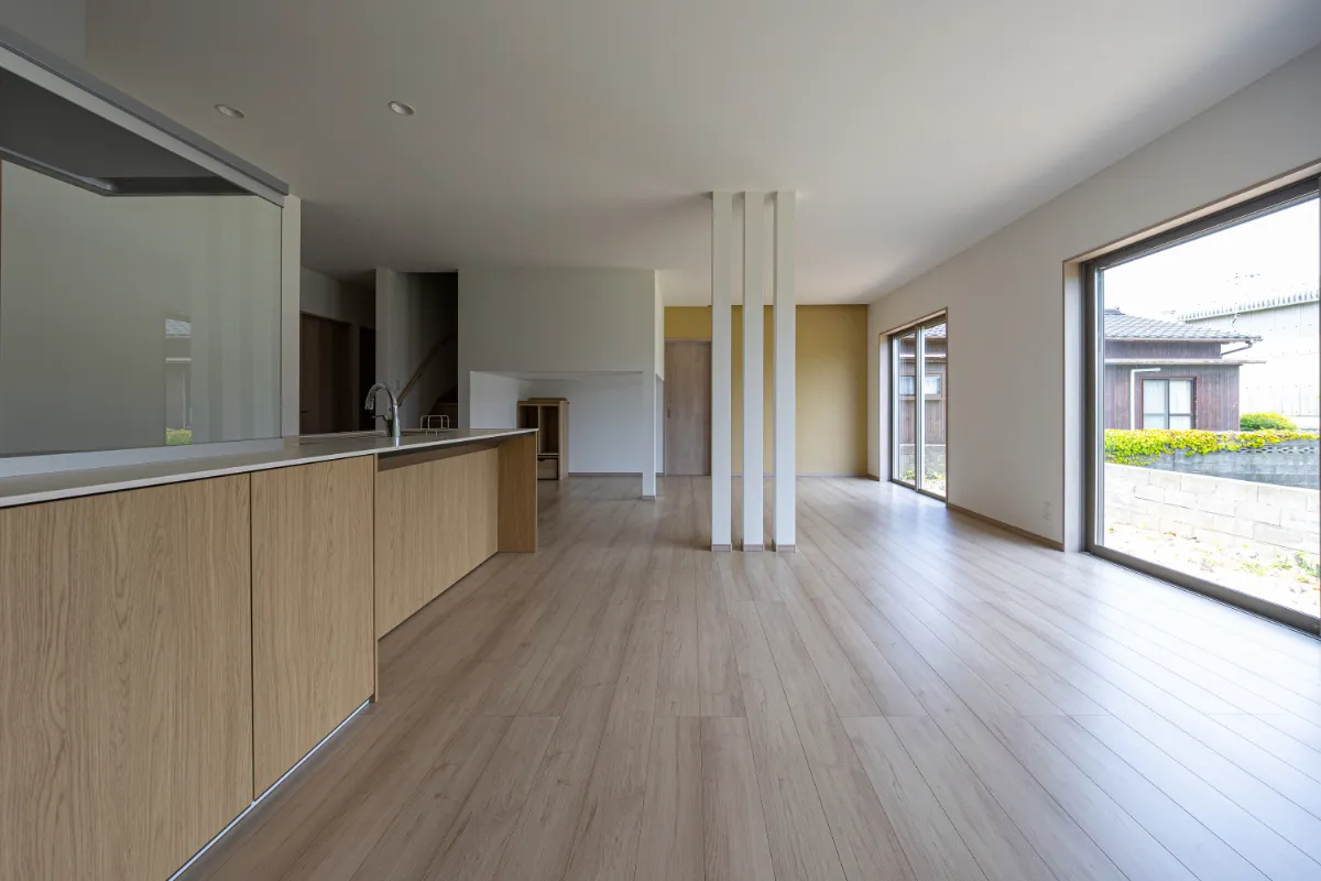 キッチン横から見たリビングの様子。奥行きのある空間が広がり、窓からやわらかな光が差し込みます。