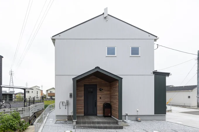 切妻屋根のシンプルなフォルムに、木目調の玄関ポーチがアクセントになった正面外観。落ち着いた佇まいに仕上げています。