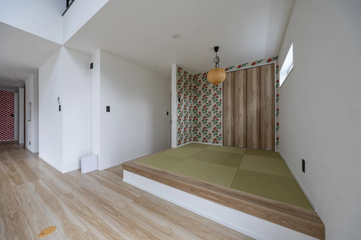 リビングとつながる小上がりの和室。畳スペースに華やかな柄クロスを合わせ、くつろぎと遊び心を感じられる空間に仕上げています。