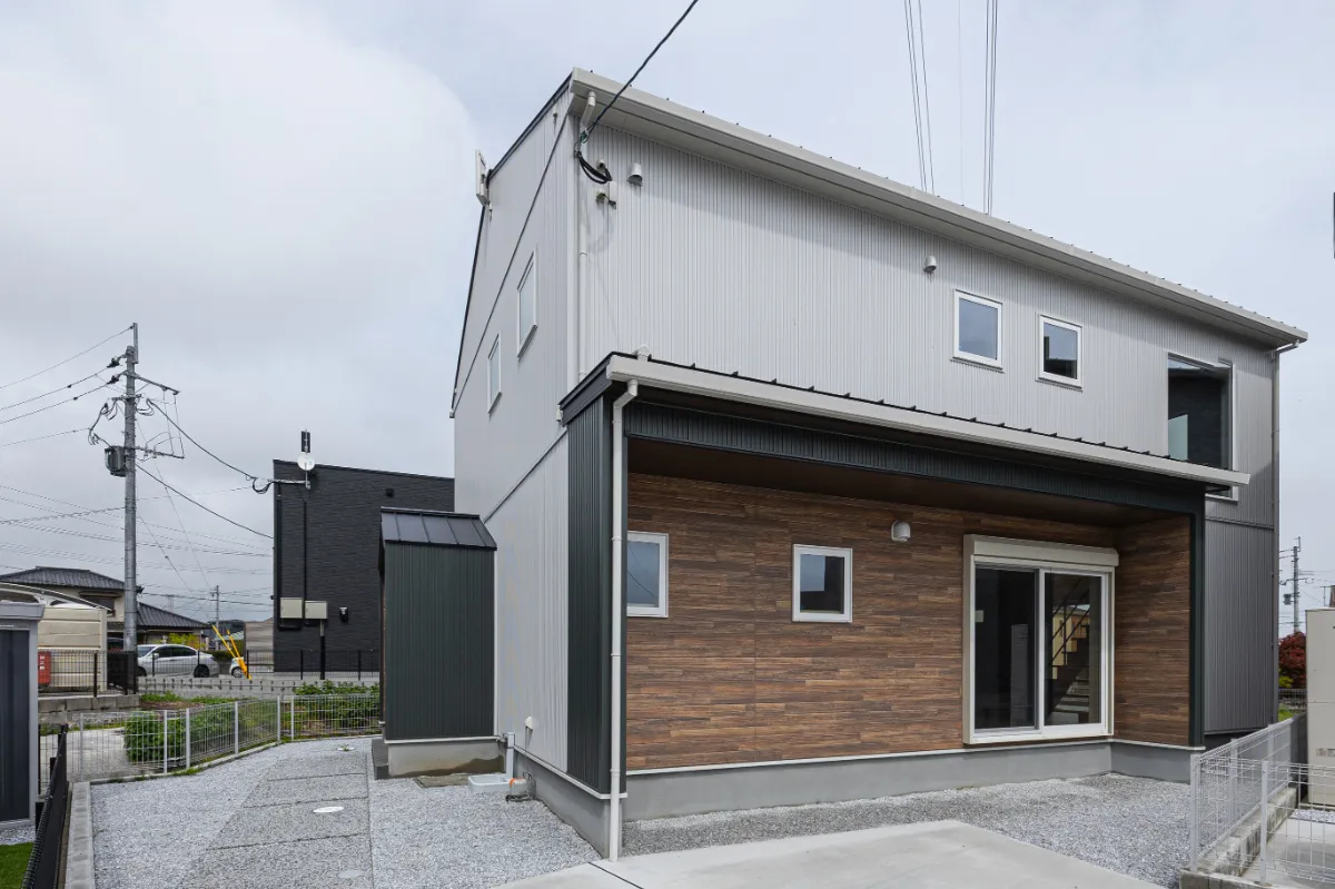 玄関部分に木目調外壁をあしらった外観デザイン。深い軒が玄関まわりを包み込み、異なる素材感がバランスよく調和した落ち着きのある佇まいに仕上げています。