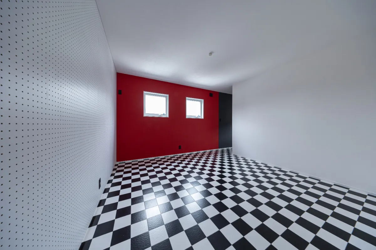 有孔ボードを設けた洋室。市松柄の床と相まって、収納やインテリアを楽しみながら使える、遊び心のある空間に仕上がっています。