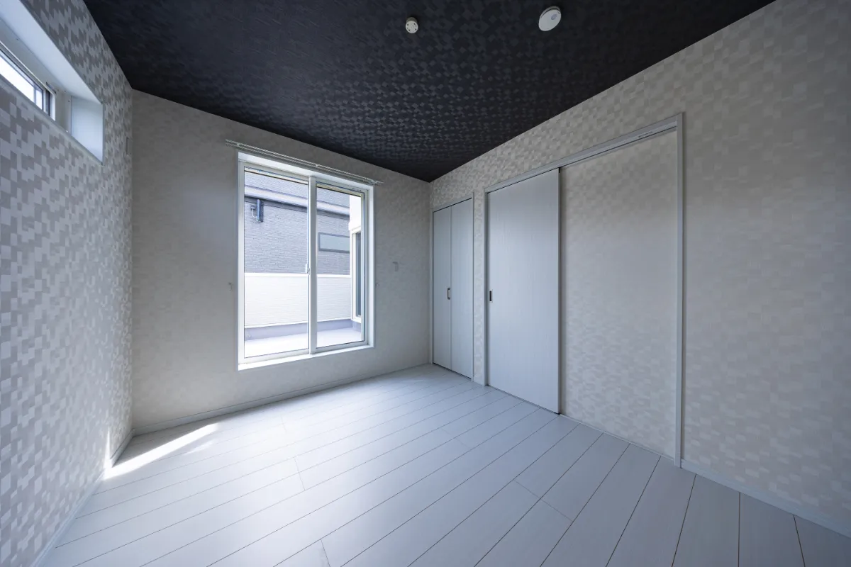 落ち着いたグレートーンでまとめた洋室。バルコニーにつながる窓から光が入り、シンプルながらも心地よい一室です。