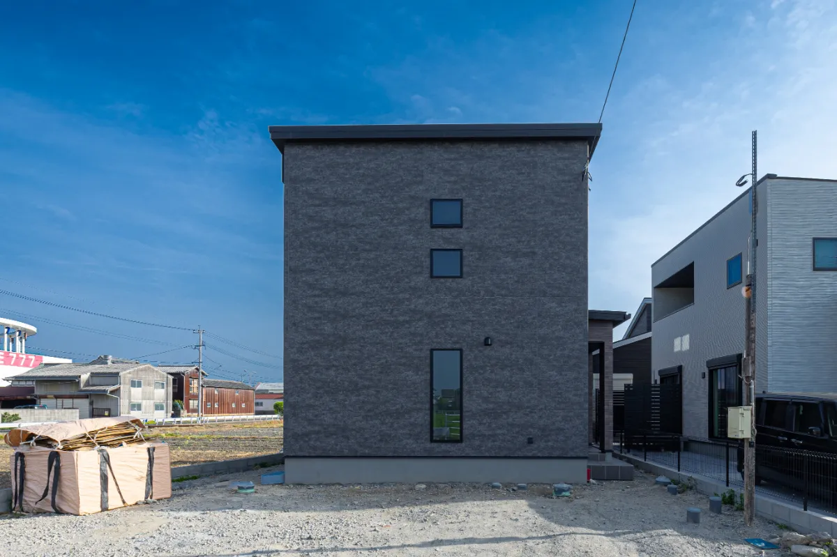 スクエアなフォルムと濃色の外壁が印象的な外観。縦に並ぶ窓が、建物にほどよいリズムを与えています。