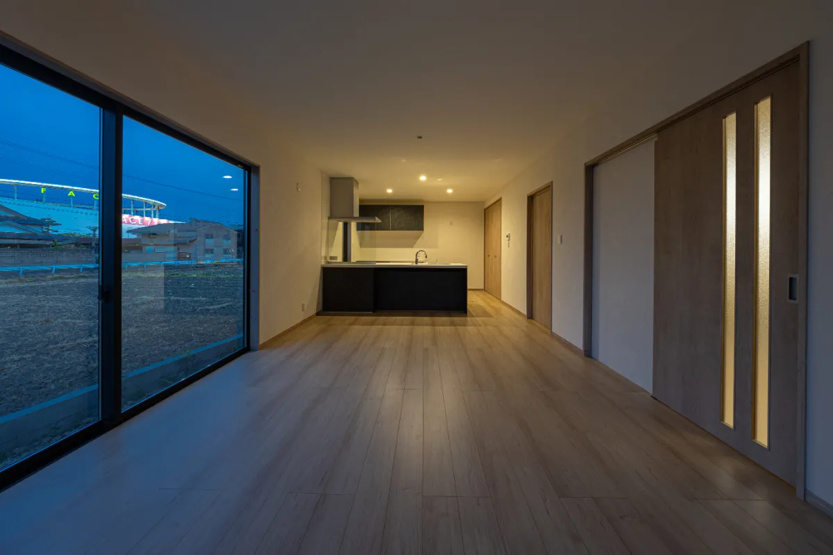 夕暮れ時のリビング。室内照明と外の景色が重なり、落ち着いた時間が流れる空間に。