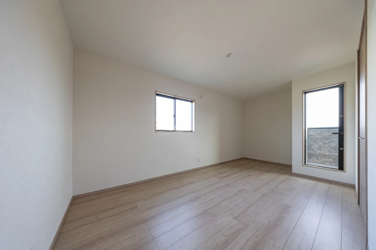 腰高窓と勝手口ドアから光を取り込む洋室。外とのつながりを感じられる配置で、明るさと開放感を確保しながら、落ち着いて過ごせるプライベート空間に仕上げています。